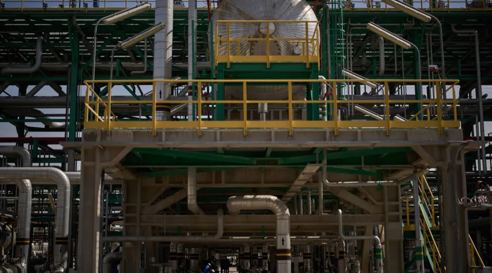 يعمل رجال على صيانة أنبوب في محطة إزالة الغازات في حقل الزبير النفطي بالقرب من البصرة (أ.ب)