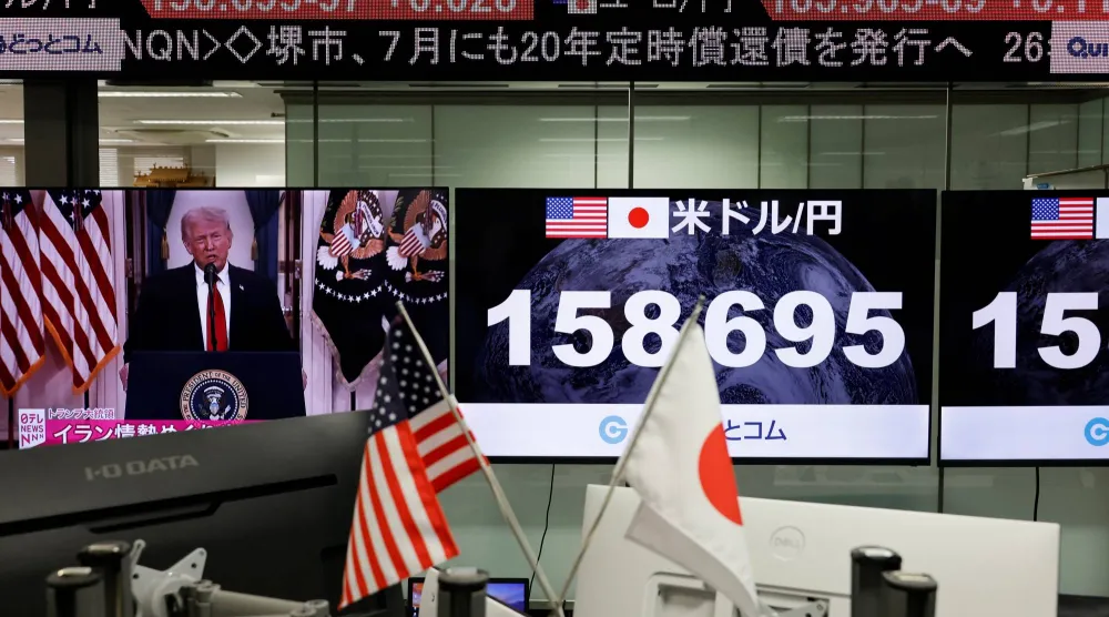 شاشة تعرض خطاب ترمب بجوار شاشات تعرض سعر صرف الين مقابل الدولار في غرفة تداول بطوكيو (رويترز)