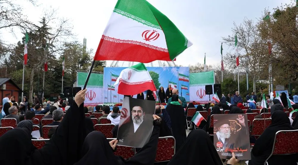 Iranian women clad in black chadors wave national flags and hold posters of Iranian Supreme Leader Mojtaba Khamenei (C) and of his late father, former Iranian Supreme Leader Ali Khamenei (R), during the annual Nature Day festival in Tehran, Iran, 02 April 2026. (EPA)