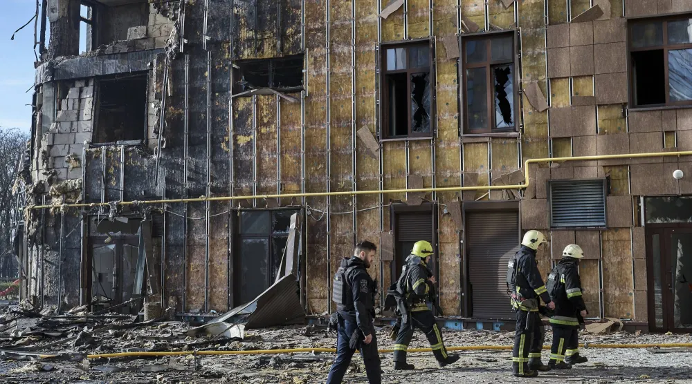 رجال إنقاذ أوكرانيون في موقع غارة روسية استهدفت مبنى سكنياً في خاركيف (إ.ب.أ)