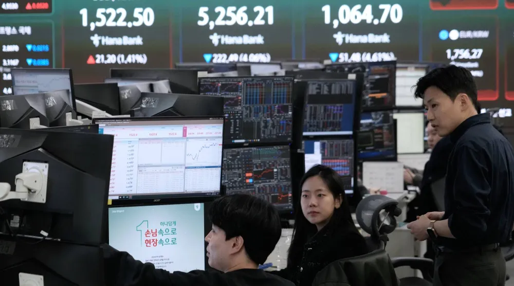 متداولو عملات أمام شاشة تعرض مؤشر «كوسبي» وسعر صرف الدولار مقابل الوون داخل مقر بنك هانا في سيول (أ.ب)