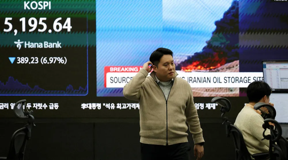 متداول عملات أمام لوحة «كوسبي» وسط تقارير عن النزاع الأميركي-الإسرائيلي مع إيران (رويترز)