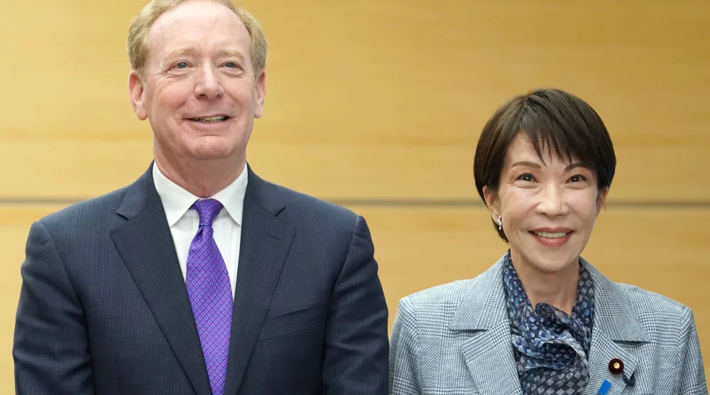 نائب رئيس مجلس إدارة «مايكروسوفت» ورئيسها براد سميث ورئيسة وزراء اليابان ساناي تاكايشي قبل اجتماع في طوكيو (أ.ب)