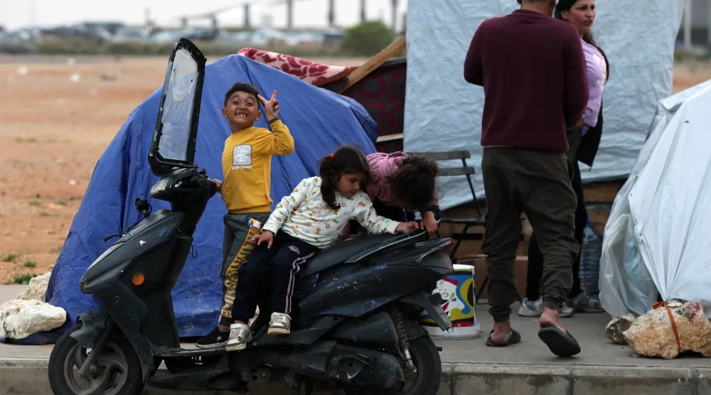 أطفال نازحون مع عائلاتهم عند الواجهة البحرية في وسط بيروت (إ.ب.أ)