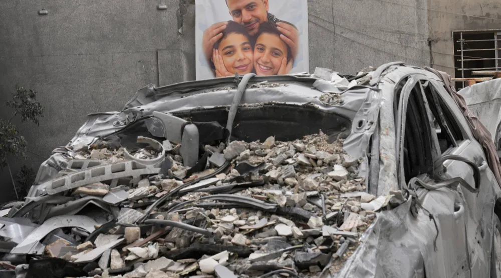 ملصق لرجل وطفلين قُتلوا جراء غارة جوية إسرائيلية استهدفت منزلهم جنوب لبنان (أ.ب)