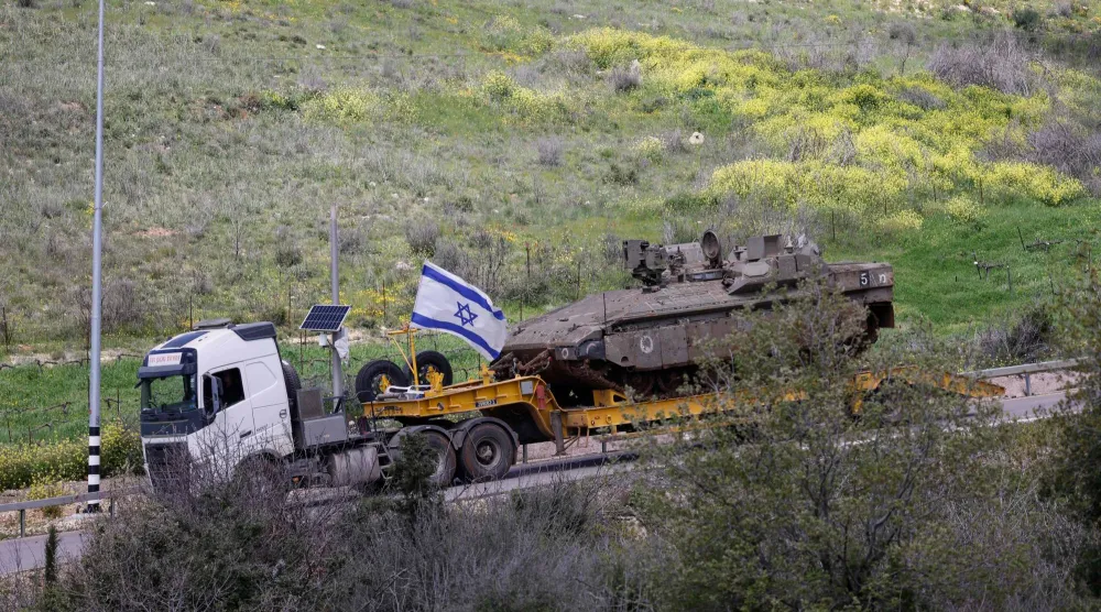 شاحنة عسكرية إسرائيلية تحمل دبابة في منطقة الجليل الأعلى شمال إسرائيل قرب الحدود مع لبنان (أ.ف.ب)