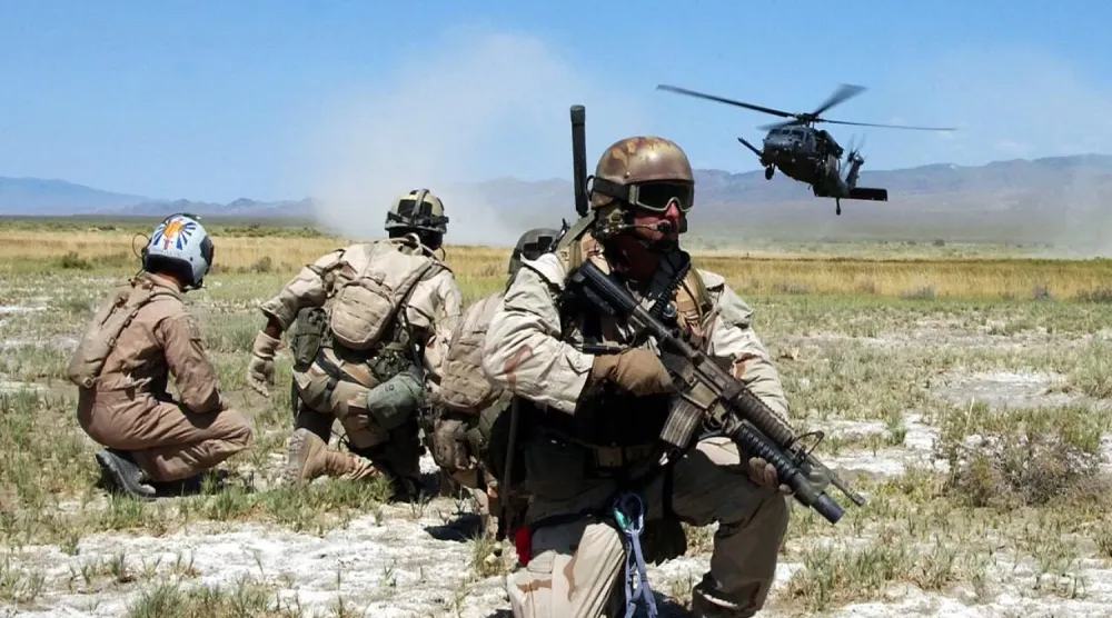  ABD Hava Kuvvetleri’ne bağlı paraşütlü kurtarma ekipleri ile ‘hayatta kalma’ tatbikatını canlandıran bir kişi, ordunun eğitim tatbikatının bir parçası olarak helikopterin inişini izliyor. (Arşiv – ABD Hava Kuvvetleri)