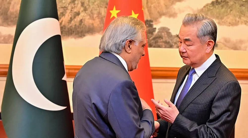 وزير الخارجية الباكستاني إسحاق دار برفقة نظيره الصيني وانغ يي في بكين يوم 31 مارس (أ.ف.ب)