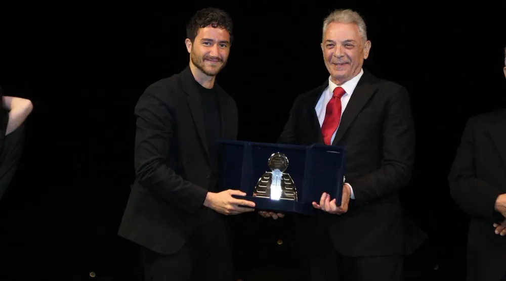 أحمد مالك متسلماً الجائزة من الرئيس الشرفي للمهرجان محمود حميدة (إدارة المهرجان)