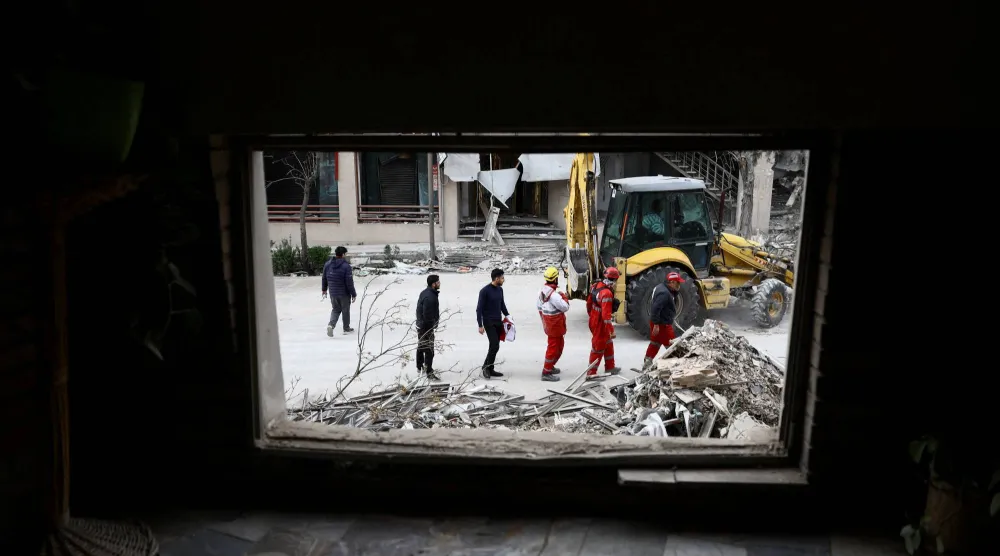 رجال الإنقاذ في موقع غارة استهدفت العاصمة الإيرانية طهران (رويترز)