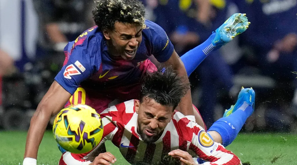 جمال يتعرض للسقوط بعد اصطدامة بغونزاليس لاعب أتلتيكو (أ.ب)