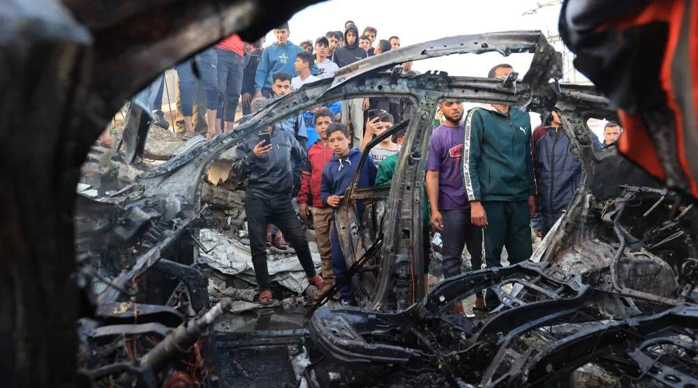 Palestinians inspect a vehicle targeted by an Israeli strike in Maghazi camp for Palestinian refugees in the central Gaza Strip on April 4, 2026. (AFP)