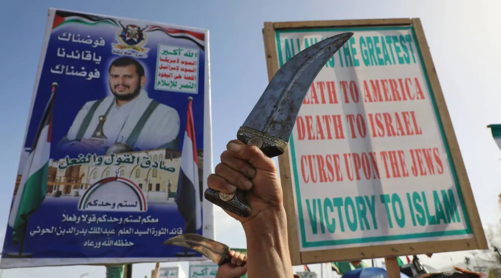 حوثيون يرفعون صورة زعيمهم خلال مظاهرة في صنعاء لتأييد إيران في حربها مع أميركا وإسرائيل (أ.ب)