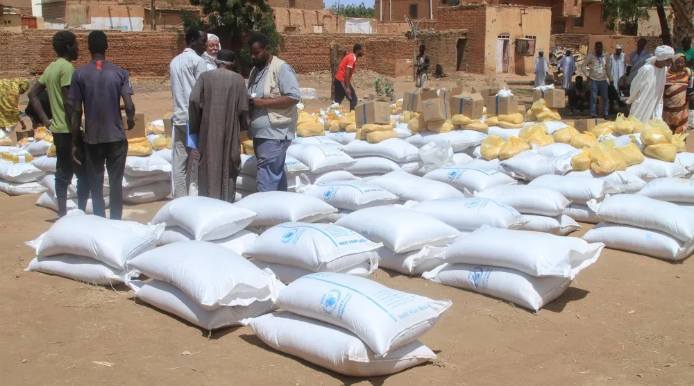 سودانيون يتلقون مساعدات من برنامج الأغذية العالمي في أم درمان يوم 11 مارس الماضي (أ.ف.ب)