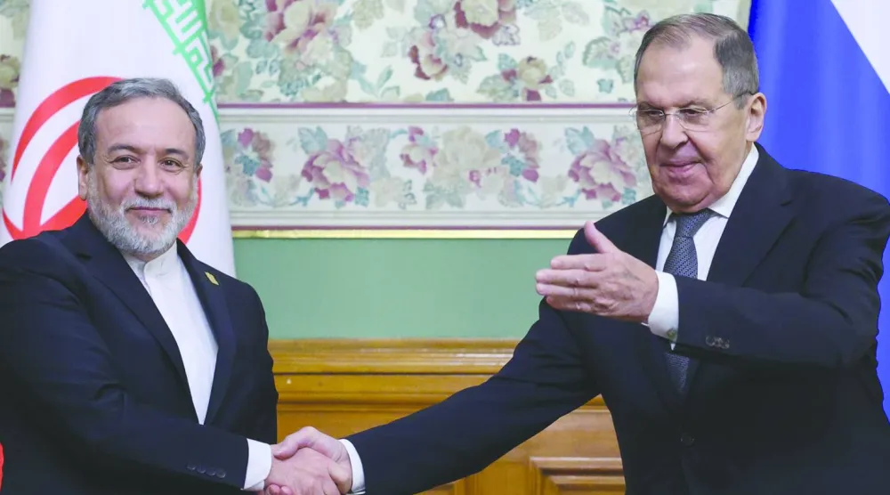 وزير الخارجية الروسي سيرغي لافروف (إلى اليمين) مصافحاً نظيره الإيراني عباس عراقجي بعد مؤتمر صحافي في موسكو 17 ديسمبر 2025 (أ.ب)
