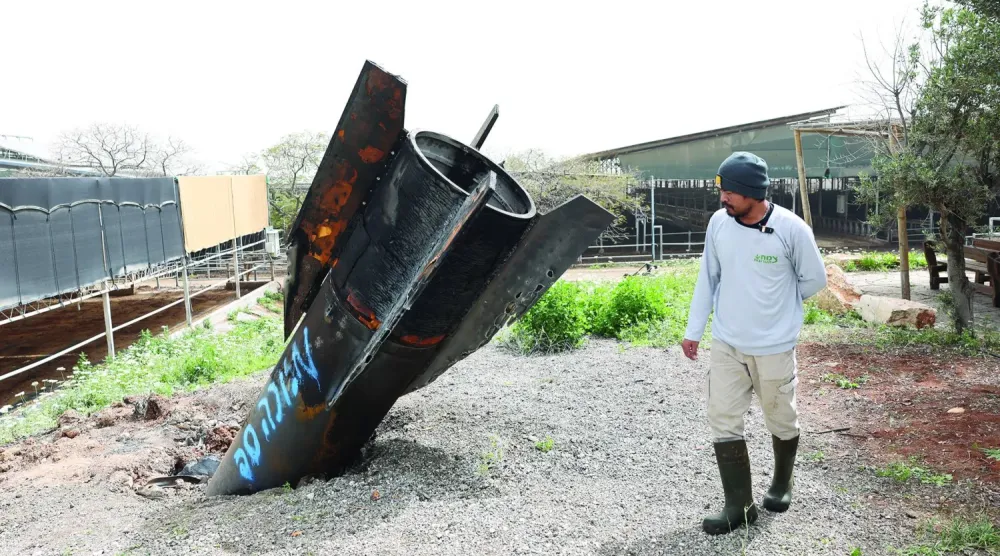 Maşur kentindeki petrokimya kompleksinde yangın çıkarken fotoğrafta Batı Şeria'daki bir İsrail yerleşiminde bir sığır çiftliğine düşen bir İran füzesinin kalıntıları görülüyor (EPA)