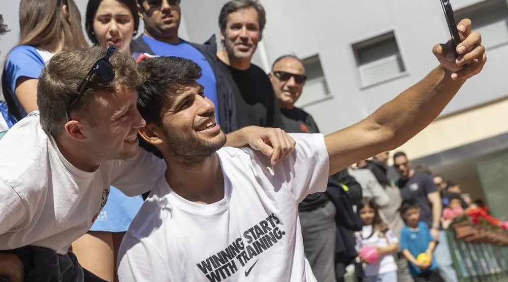 Spanish tennis player Carlos Alcaraz poses for a selfie with a fan after his training session held at Murcia Royal Tennis Club 1919 in Murcia, Spain on 31 March 2026. (EPA)