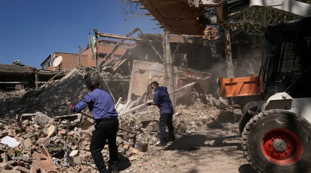 İranlı yetkililerin bugün ABD-İsrail hava saldırısıyla vurulduğunu söylediği Tahran'daki Şerif Teknoloji Üniversitesi kompleksinde işçiler enkazı kaldırıyor (AP)
