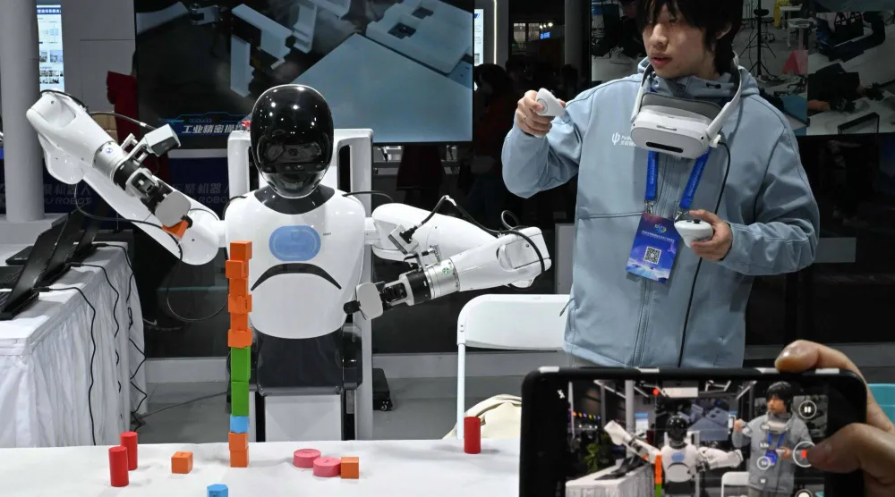 مهندس يتحكم في روبوت من شركة «تاشان» خلال مهرجان بكين (أ.ف.ب)
