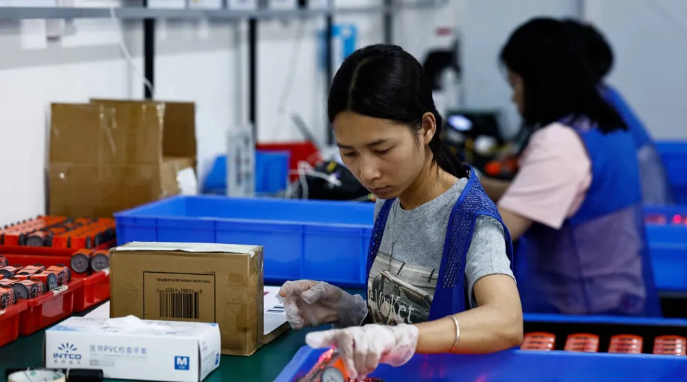 عمال في خط إنتاج تابع لشركة «أجيليان» للتكنولوجيا في مدينة دونغقوان الصينية (رويترز)