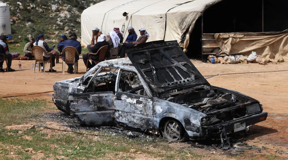 سيارة أحرقها المستوطنون الإسرائيليون في هجوم على بلدة اللبن قرب نابلس بالضفة الغربية يوم الاثنين (إ.ب.أ)