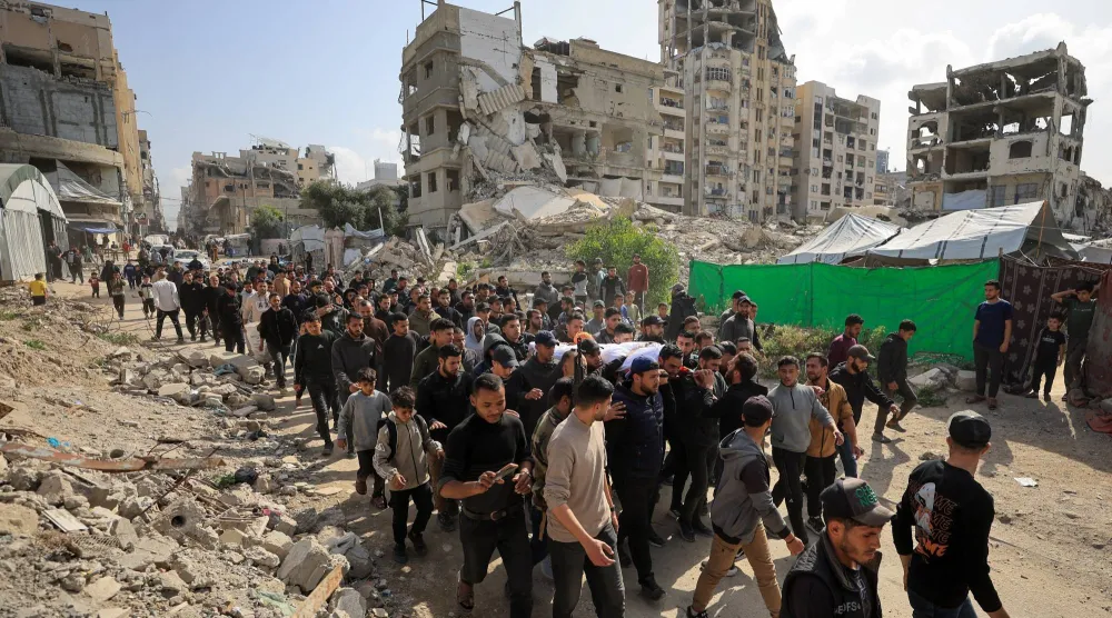 مشيعون يحملون يوم الاثنين جثمان الفلسطيني عبد الرحمن الخضري الذي قُتل في غارة إسرائيلية في مدينة غزة يوم الأحد (رويترز)