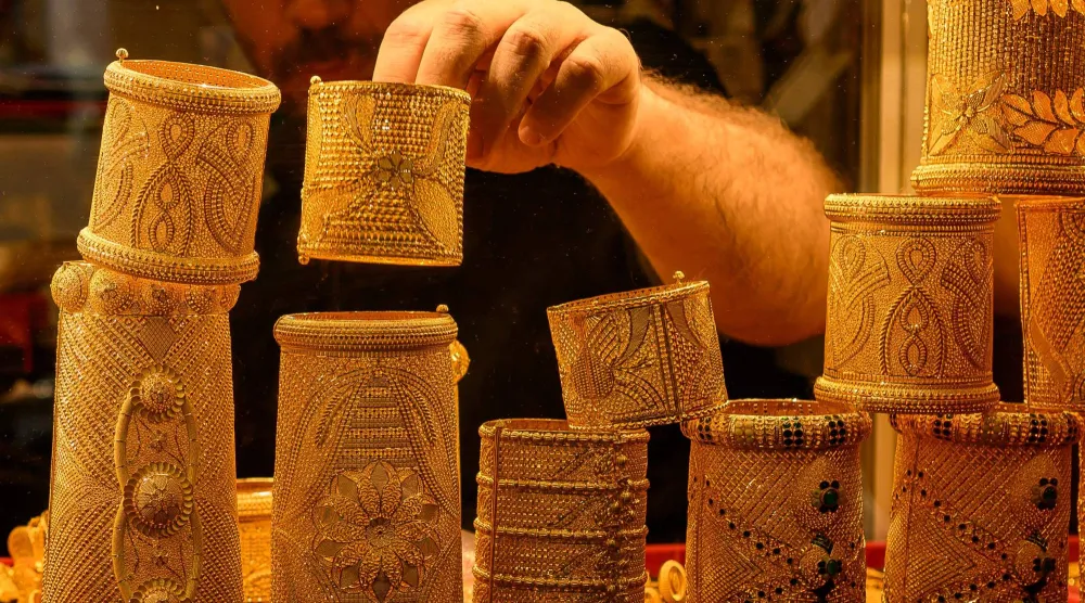 بائع يعرض أساور ذهبية بمتجر في البازار الكبير بإسطنبول (أ.ف.ب)