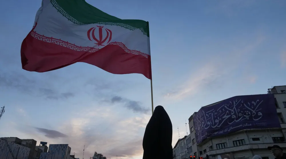 إمرأة تحمل علم إيران (أ.ب)