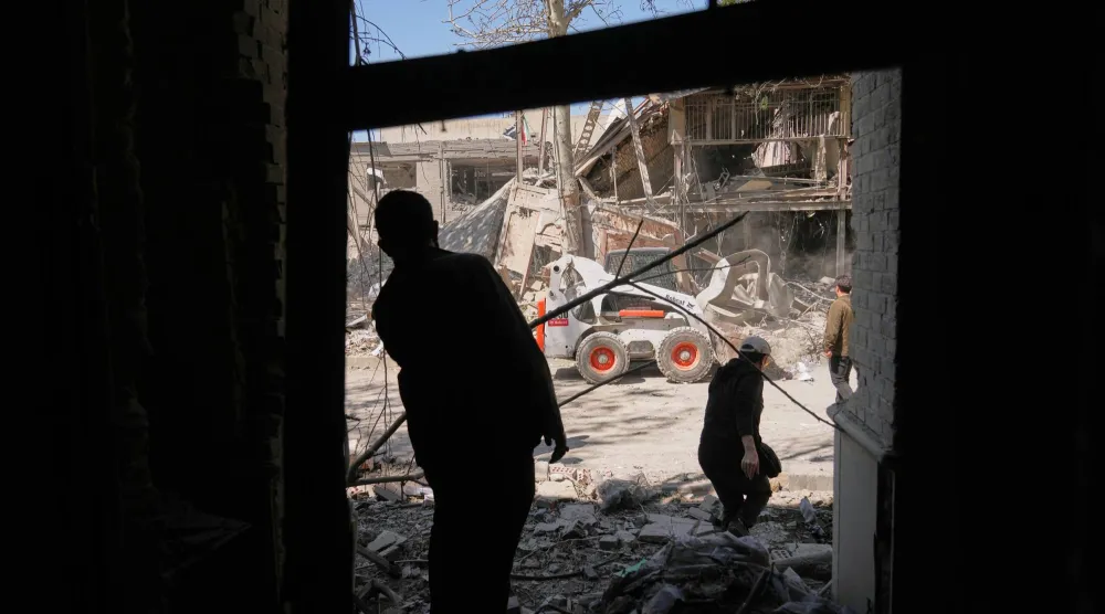 عمال يزيلون الأنقاض في مجمع جامعة شريف للتكنولوجيا في طهران (أ.ب)