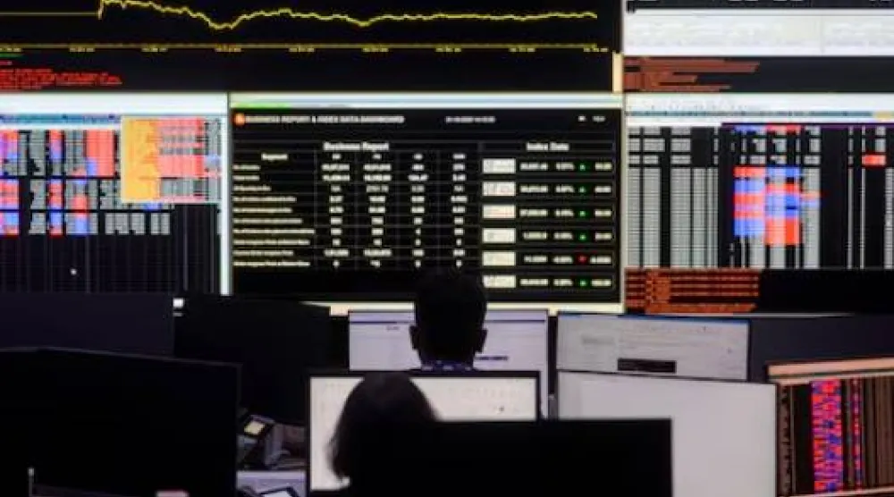 وسطاء الأسهم يتابعون شاشات التداول في بورصة مومباي (رويترز)