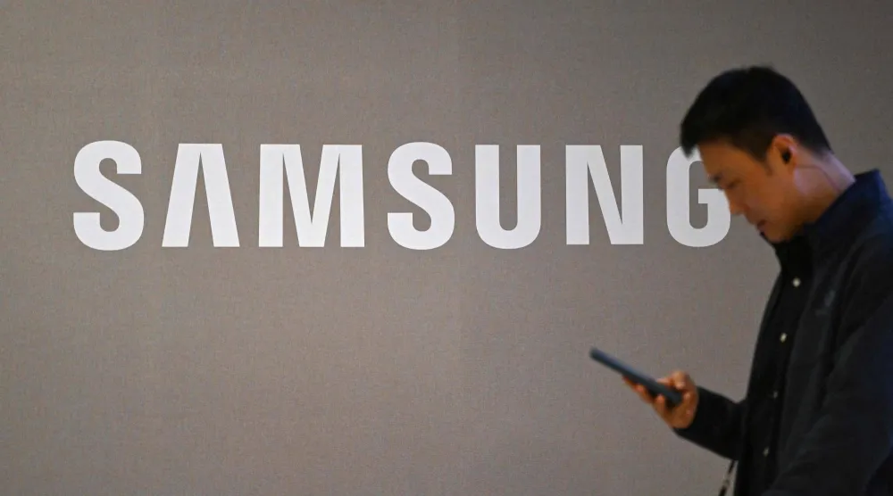 يمر رجل بجوار شعار «سامسونغ» المعروض على مبنى الشركة في سوتشو - سيول (أ.ف.ب)