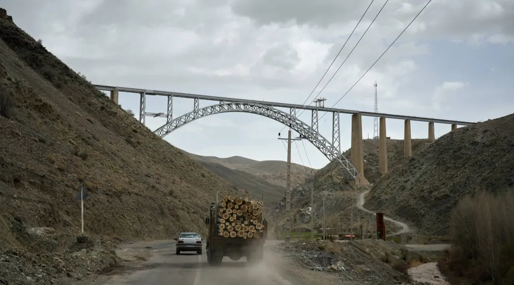 شاحنة محملة بالأخشاب ومركبات أخرى تسير على طريق باتجاه طهران قرب الحدود التركية (أ.ب)
