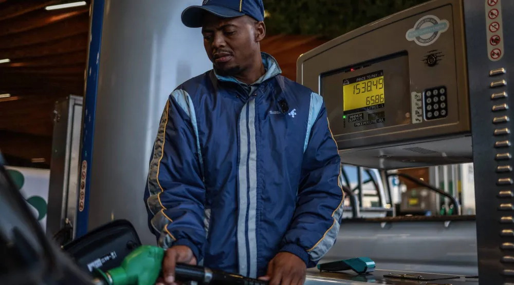 عامل يزود سيارة بالوقود في محطة بنزين في روزبانك بجوهانسبرغ (أ.ف.ب)