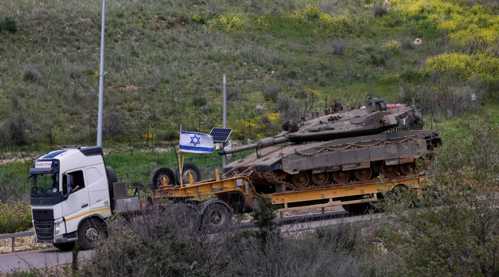 شاحنة عسكرية إسرائيلية تحمل دبابة في منطقة الجليل الأعلى شمال إسرائيل بالقرب من الحدود مع لبنان (أ.ف.ب)