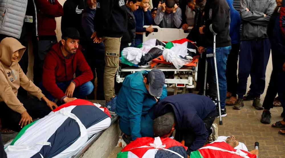 جنازة فلسطينيين قُتلوا بغارة إسرائيلية في مستشفى شهداء الأقصى بدير البلح وسط قطاع غزة (رويترز)