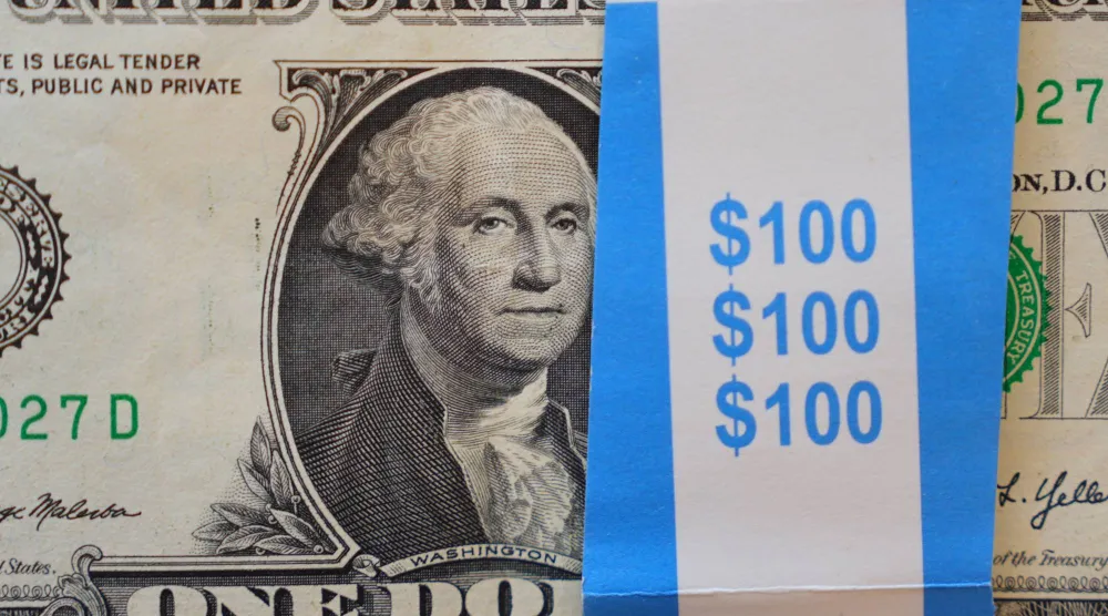 صورة لجورج واشنطن معروضة على كومة من الأوراق النقدية الأميركية من فئة الدولار الواحد في دالاس (أ.ب)