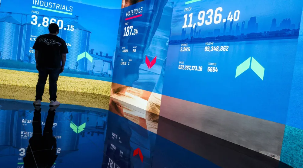 رجل يتابع سوق الأسهم في سوق دبي المالي بدبي (إ.ب.أ)