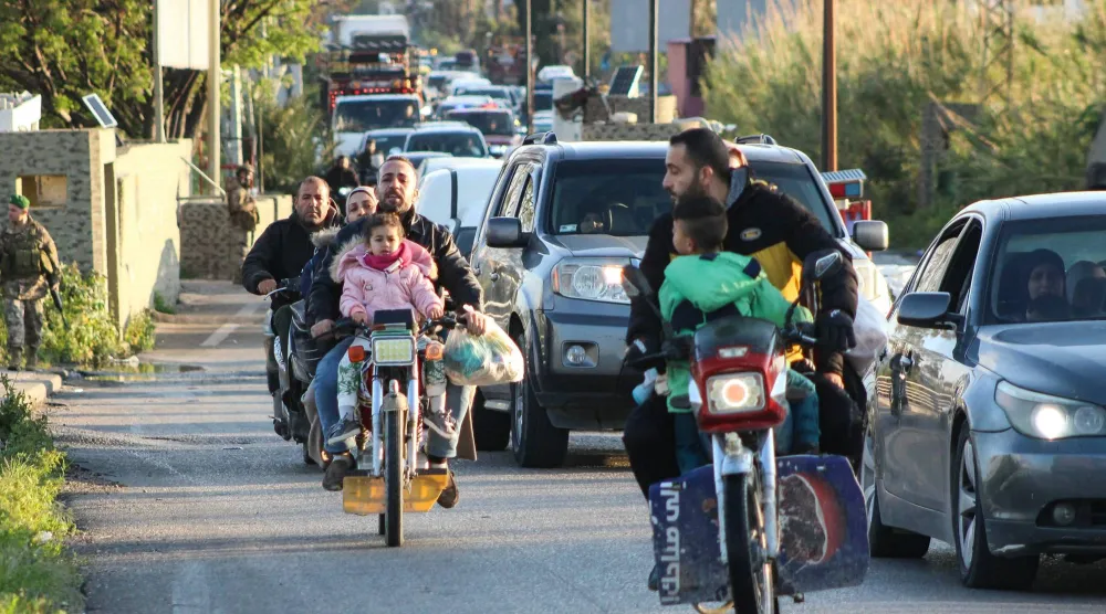 سيارات تعبر نقطة تفتيش عسكرية بمنطقة القاسمية متجهةً نحو جنوب لبنان فجر اليوم (أ.ف.ب)