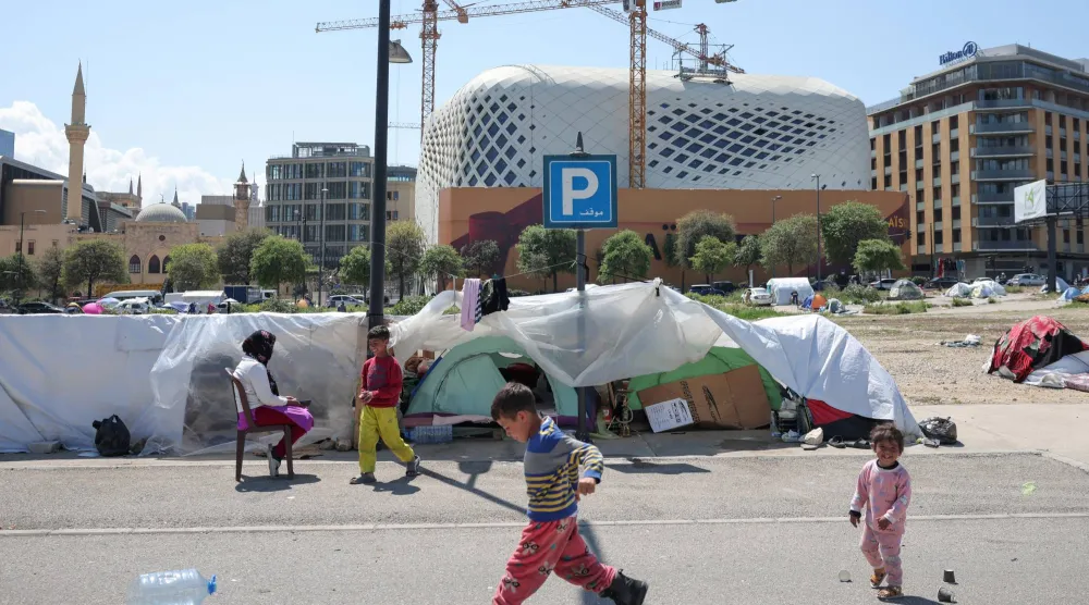 أطفال نازحون يلعبون قرب خيامهم المؤقتة في بيروت (رويترز)