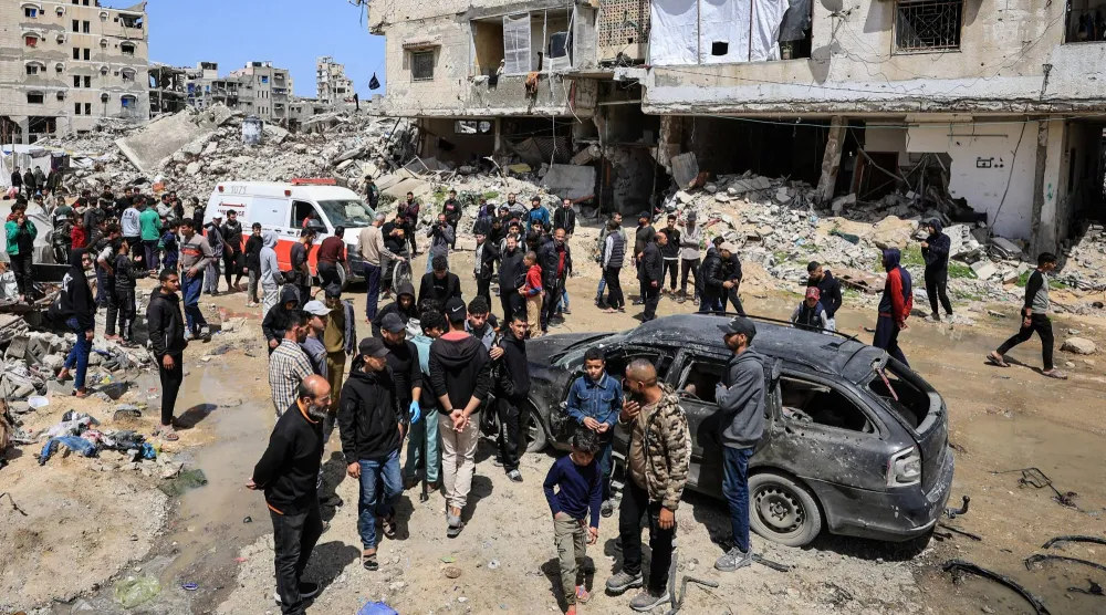 فلسطينيون يتفقدون الأضرار بعد قصف إسرائيلي في مدينة غزة يوم الاثنين (رويترز)