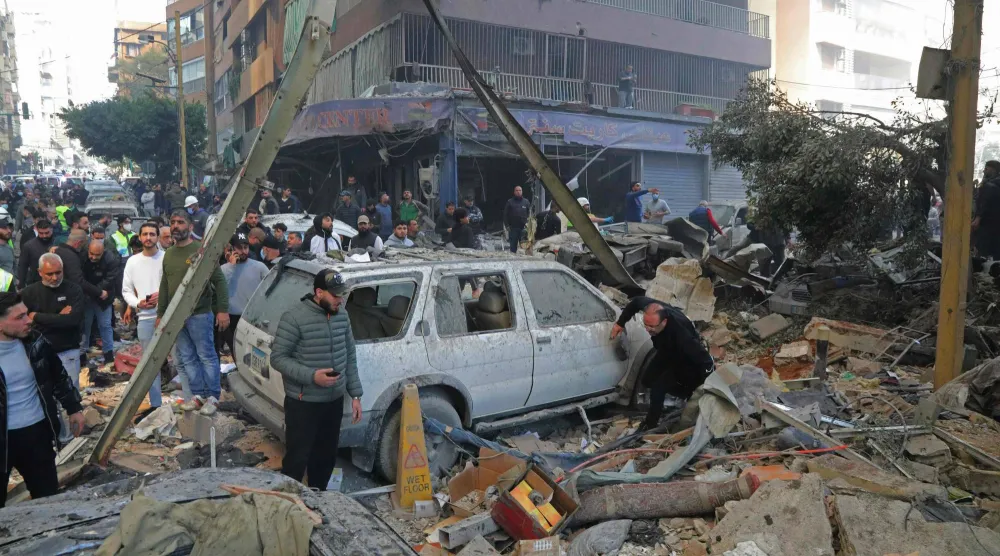 عناصر الدفاع المدني ومواطنون في موقع استُهدف بقصف إسرائيلي في منطقة كورنيش المزرعة في بيروت (أ.ف.ب)