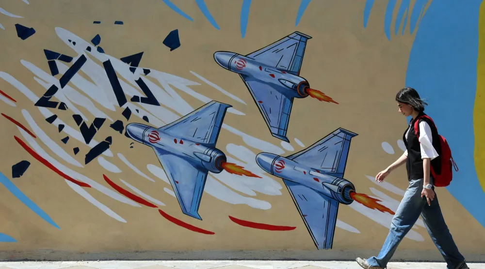 إيرانية تمر أمام لوحة جدارية مناهضة للولايات المتحدة وإسرائيل في طهران الأربعاء (إ.ب.أ)