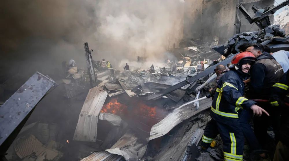 رجال الإطفاء والمسعفون والمتطوعون يعملون على إزالة الأنقاض في موقع غارة إسرائيلية على بيروت (أ.ب) 
