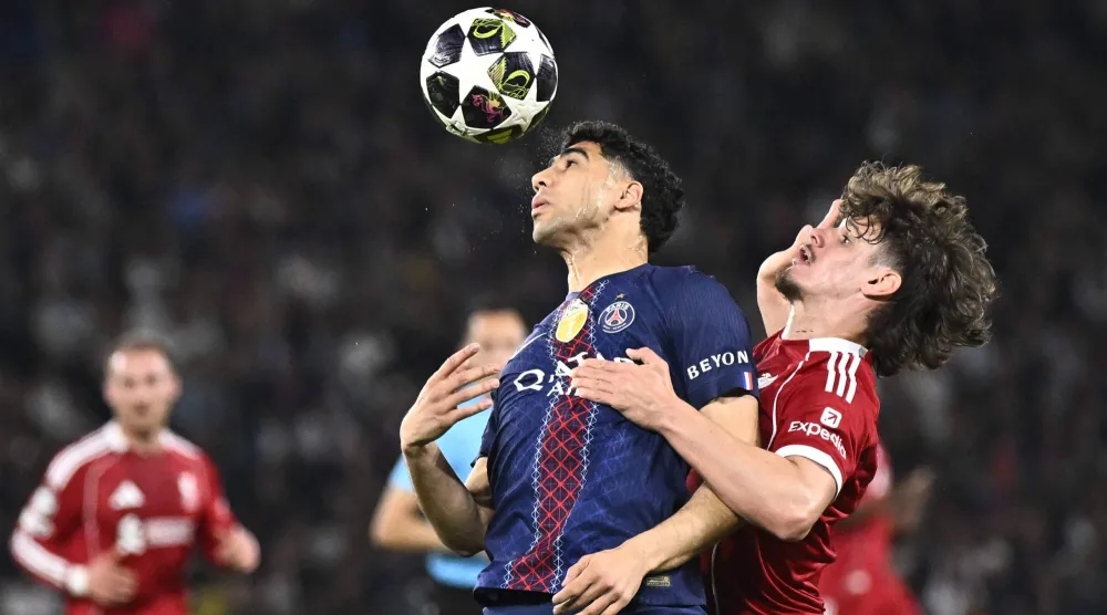 حكيمي يرتقي للكرة وسط مضايقة كيركيز لاعب ليفربول (أ.ف.ب)