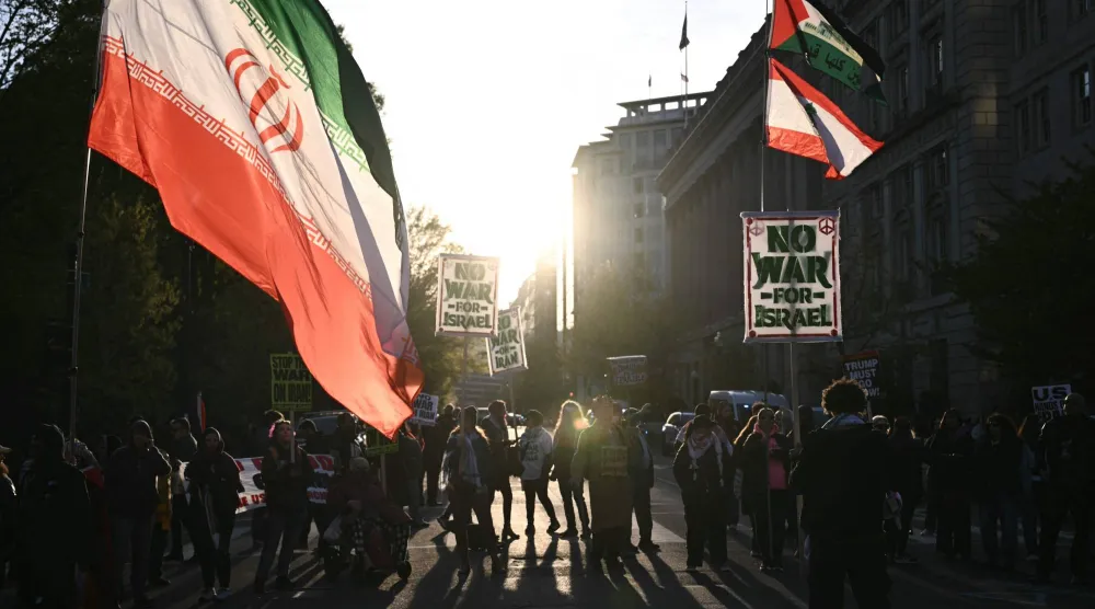 متظاهرون يرفعون أعلام إيران خلال الاحتجاج على العمليات العسكرية الأميركية في إيران بالقرب من البيت الأبيض في واشنطن العاصمة أمس (أ.ف.ب)