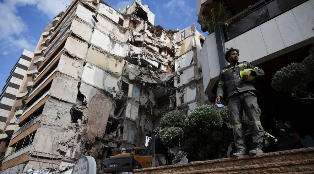 ينظر أحد رجال الإنقاذ بالقرب من مبنى متضرر في موقع غارة إسرائيلية نُفذت يوم الأربعاء في تلة الخياط ببيروت (رويترز)