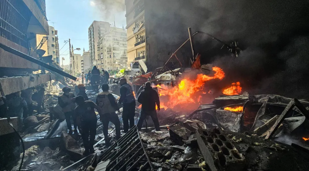 TOPSHOT - First responders stand amid rubble at the site of an Israeli airstrike in Beirut's Corniche al-Mazraa neighborhood on April 8, 2026.  (Photo by AFP)