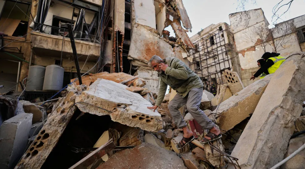 رجل يسير على أنقاض مبنى دمرته غارة جوية إسرائيلية في اليوم السابق بوسط بيروت - لبنان (أ.ب)