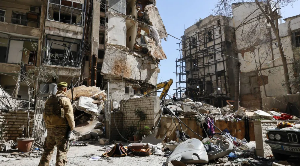 جندي من الجيش اللبناني يقف بجوار مبنى سكني مُدمَّر في اليوم التالي لغارة جوية إسرائيلية على حي عين المريسة ببيروت (إ.ب.أ)