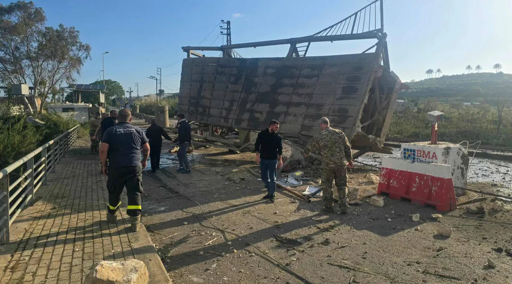 عناصر من الدفاع المدني يتفقدون الأضرار الناتجة عن قصف إسرائيلي استهدف جسر القاسمية فوق نهر الليطاني بجنوب لبنان (أ.ف.ب)
